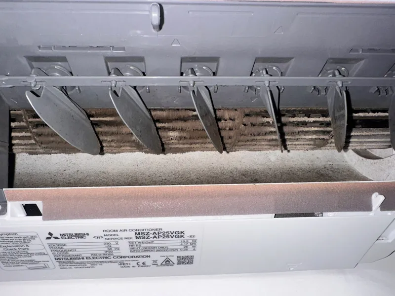 Lamelas e turbina de uma unidade Mitsubishi cobertas de pó acumulado, antes da limpeza profunda